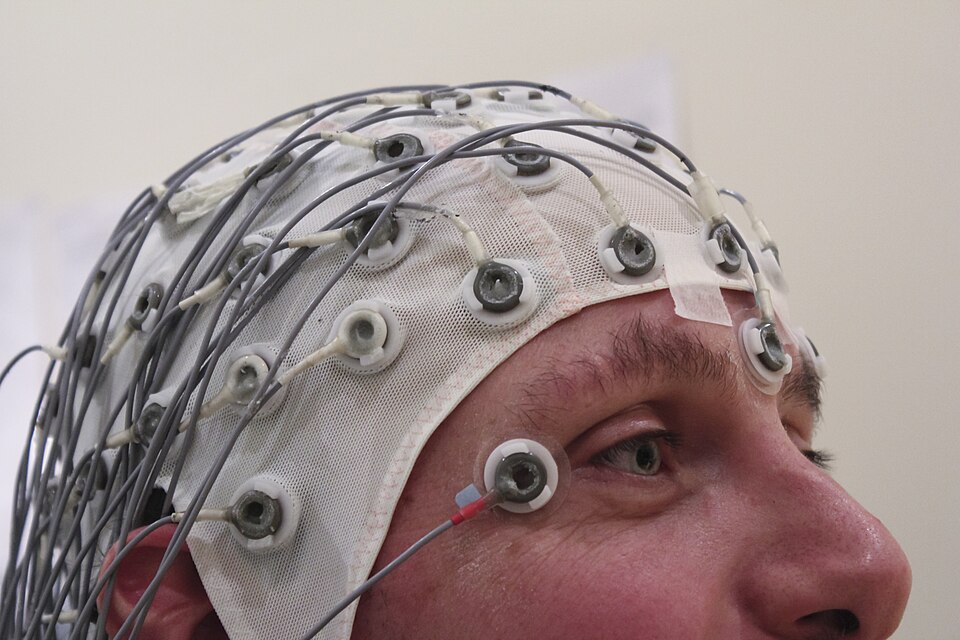 Person wearing an EEG recording cap with electrodes